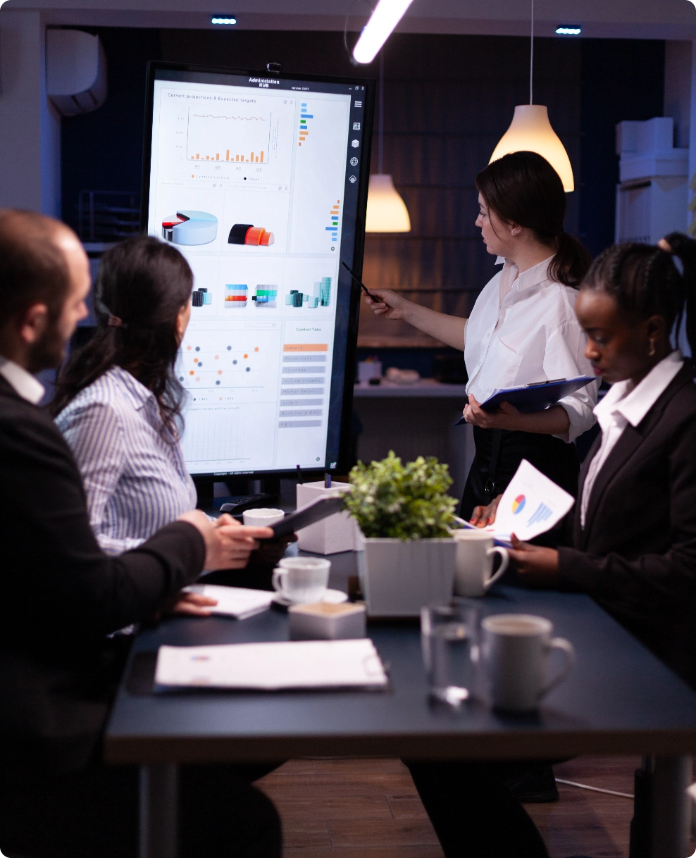 diverse-multi-ethnic-business-teamwork-overworking-office-meeting-room-analyzing-financial-graphs@2x